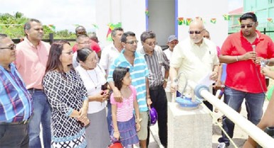 GWI’s Chief Executive Officer, Shaik Baksh (third from right) President Donald Ramotar (second from right) and Housing and Water Minister Irfaan Ali (right) check the water flow from the newly commissioned Lethem well. (GINA photo)