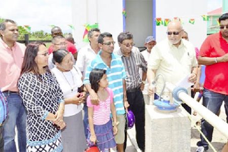 GWI’s Chief Executive Officer, Shaik Baksh (third from right) President Donald Ramotar (second from right) and Housing and Water Minister Irfaan Ali (right) check the water flow from the newly commissioned Lethem well. (GINA photo)