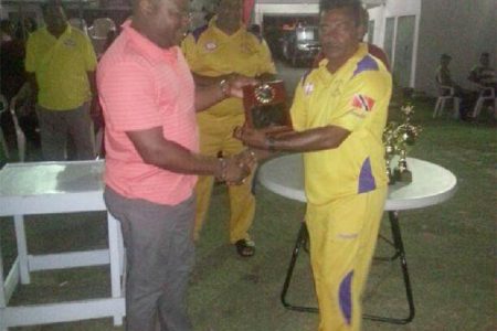 Everest Cricket Club President Stephen Lewis hands over several of the club’s Centennial magazine to Preysal Captain.
