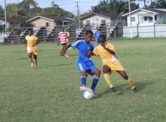 Ronnel Roberts (left) of Santos battling Keith Caine of Beacons during their u17 matchup.