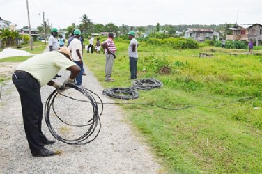 A GPL worker rolling up the illegal wires that were removed in Skull City (GINA photo) 