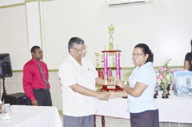 Minister of Labour, Dr. Nanda Gopaul (left) on Monday  handing over a prize to a teacher of the Vreed-en-Hoop Primary School. The school placed first in the essay competition for World Day for Occupational Safety and Health. (GINA photo) 