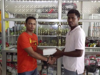 Ato Singh (left) of Tiger Sport presents the balls to Benedict Prince of Quest International. 