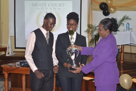 Dr. Carol Bishop (right) presenting the trophy for the Prof. Aubrey Bishop Annual Moot Competition to law students Sherrie Hewitt and Kevin Morgan   at the Moot Court Guyana exhibition held at the university’s Education Lecture Theatre yesterday. (GINA photo)