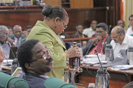 APNU MP Volda Lawrence holding up a bottle of rum as she argued that alcohol was a major scourge in the country that had to be addressed. She was contributing to the budget debate.