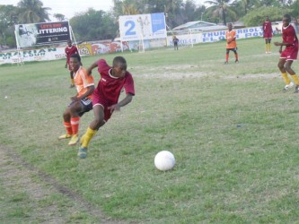 BK Western Tigers forward Shane Morris (red) initiating a counter-attack after evading Fruta Conquerors winger Randy Layne (orange) during his team’s 2-0 loss