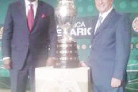  CONCACAF president Jeff Webb (left) poses with South American counterpart Eugenio Figueredo, and the Copa America trophy.