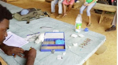 A health worker records the result of a smearing exercise.