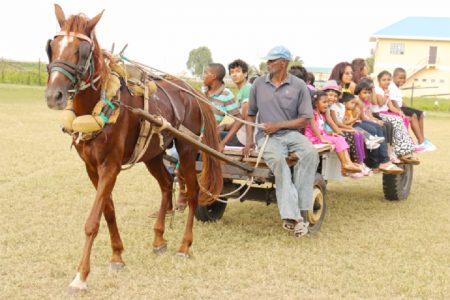Horse cart ride: Parents and children being treated to a horse cart ride at the Marian Academy Fair at the Softball Ground, Carifesta Avenue yesterday. (Photo by Arian Browne)
