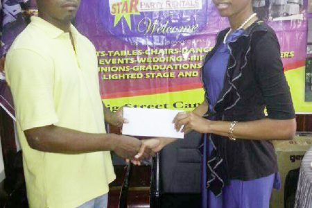 Ms. Kesheka Washington of Star Party Rental hands over the cheque to Bendict Prince of Quest International.
