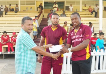 Chris Barnwell and Paul Wintz receives the winning check of GY$500, 000 from GCB Secretary Anand Sanasie  