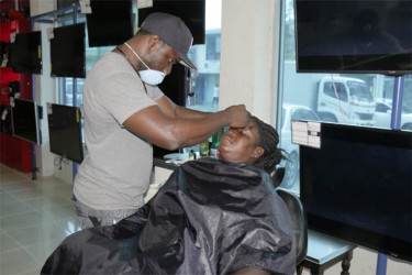 A mother having her eyebrows lined yesterday at the American Stores.