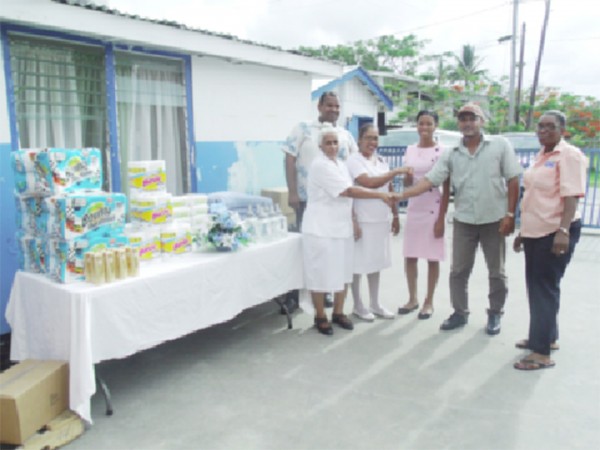  Food for the Poor (Guyana) Inc donated a number of items to the Chest Clinic of the Georgetown Public Hospital Corporation recently. Nurse in charge of the clinic, Sursattie Rajcumar said that the charity has been donating items to the clinic for about five years, according to a press release. The items are very useful to the nurses and to the patients, she said, and commended the organisation for its continuous support to the health sector. The charity’s PR Manager, Wayne Hamilton, said it is cognisant of the needs of the health sector and the difficult conditions that nurses operate under daily, and pledged to lend support whenever possible to the hospital. In picture: Hamilton (second from right) shares a handshake with Rajcumar while other representatives look on.  The items are displayed on a table at left. 