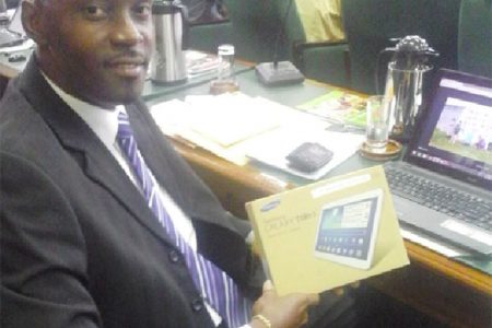 APNU Member of Parliament Christopher Jones holds the Samsung Tablet he received.