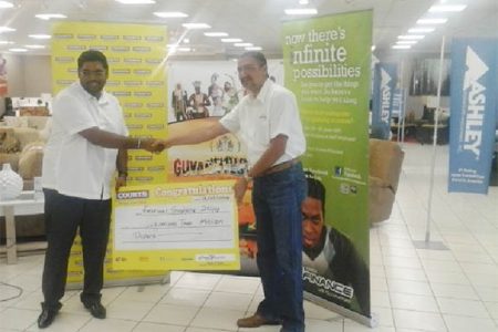 Tourism Minister Irfaan Ali receives the $2 million cheque from Managing Director of Courts Guyana, Clyde De Haas