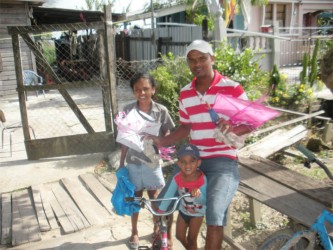 Narisa Alleyne (left), Kapaldil Kissoon (middle) and Ramnarine Ramdihall preparing to fly their kites left over from Easter.