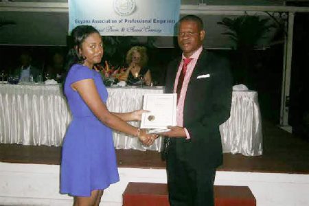 Nkechi Mc Pherson receiving the Phillip Allsopp award from President of the Guyana Association of Professional Engineers Kwame Pindar at the association’s 46th anniversary dinner on Saturday evening at the Georgetown Club.