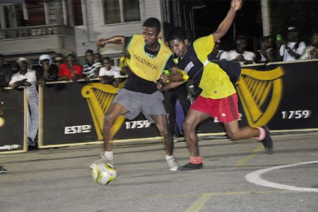 Threon Petre (left) of BV-B attempting to keep possession of the ball while being challenged by his Melanie-B marker during his side’s semi-final win