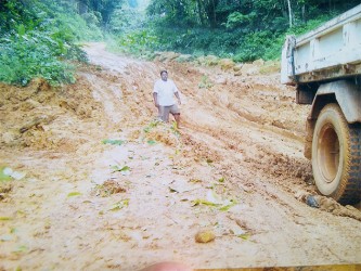 A driver standing in the depth of the eroded Mahdia Road