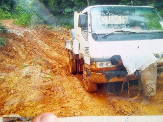 A truck driver on the deteriorated Mahdia Road preparing to have his vehicle pulled out