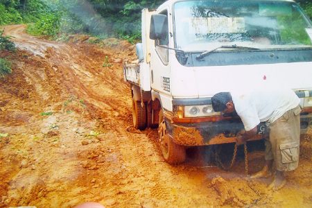 A truck driver on the deteriorated Mahdia Road preparing to have his vehicle pulled out