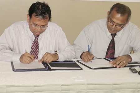 Culture Minister Frank Anthony and Radha Krishna Sharma, CEO of GT&T sign the $10 million MoU for the documentation of the National Collection. (Photo by Arian Browne)
