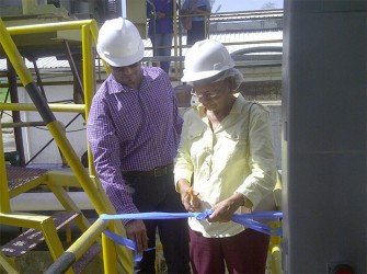 Minister of Natural Resources and the Environment Robert Persaud and Bibi Webster, widow of late CCI CEO Ronald Webster, cutting the ribbon to officially commission the Tetra Pak recycling plant. 