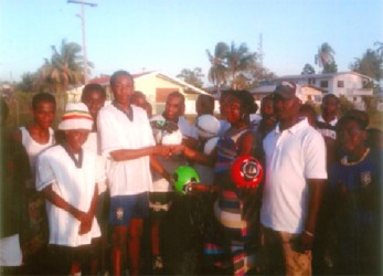 Captain of the Renaissance U17 football team Idony Jobe receives the footballs from a staff of Dynasty Sports Club and Bar.