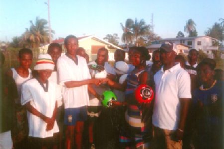 Captain of the Renaissance U17 football team Idony Jobe receives the footballs from a staff of Dynasty Sports Club and Bar.