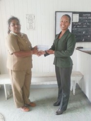 Priya Rampersaud of Sentinel Security Inc. hands over cheque to Cosmatia Lindie. 