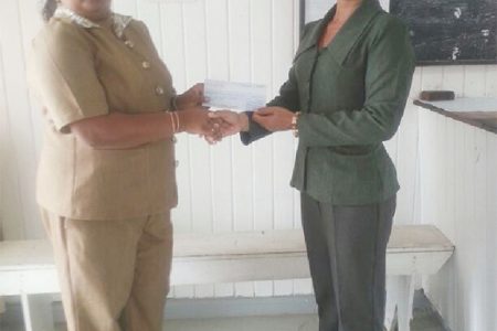 Priya Rampersaud of Sentinel Security Inc. hands over cheque to Cosmatia Lindie.