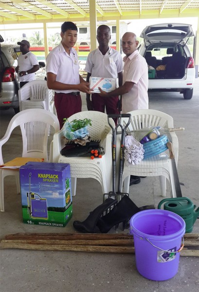 Representatives from Global Youth Movement – Guyana presenting a gift of agricultural tools to representatives from secondary schools in Region Five 