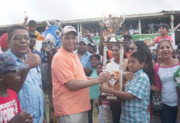 Owners of Score’s Even accepts the winning trophy from Minister of Home Affairs and General Secretary of the PPP/C, Clement Rohee. (Orlando Charles photo) 