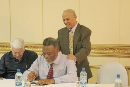 Dr Yesu Persaud (standing) in a humorous exchange with Prime Minister Sam Hinds (sitting at right) and Dr Ian McDonald.
