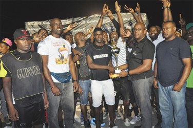 Melanie-A captain Dwight Peters collecting the championship trophy from East Coast of Demerara East Coast Branch Guinness Supervisor Clive Pellew (right) while members of the winning team, Banks DIH Limited and the Petra Organization look on 