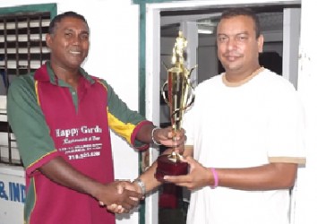 Captain of the Everest Masters Rajesh Singh (right) collects the winning trophy from Enterprise skipper Seemangal Yadram.  