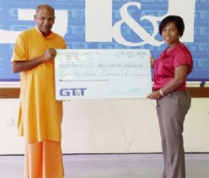 In this GT&T photo, GT&T’s Nicola Duggan makes the presentation to the swami. 