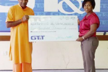 In this GT&T photo, GT&T’s Nicola Duggan makes the presentation to the swami.