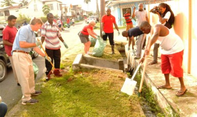 US Ambassador Brent Hardt (second, left) lends a hand with a rake 