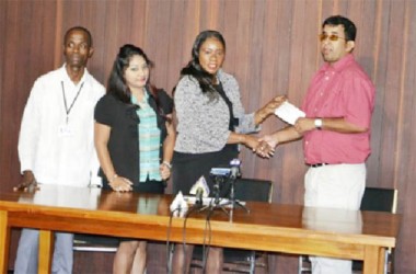 Minister of Human Services and Social Security, Jennifer Webster handing over the cheque to Ganesh Singh, while staff from the OLPF Secretariat look on. (GINA photo)
