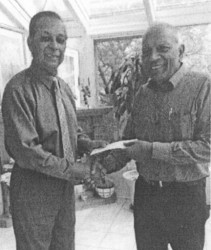 Leader of the Blairmont Crematorium project Nowrang Persaud, (left) receives the first two cheques from Trevor Subryan 