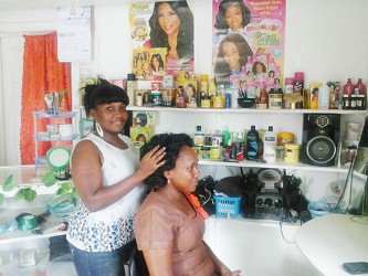 Jennifer Holder fixes a  client’s hair