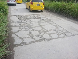 A roughly patched portion of the road. 