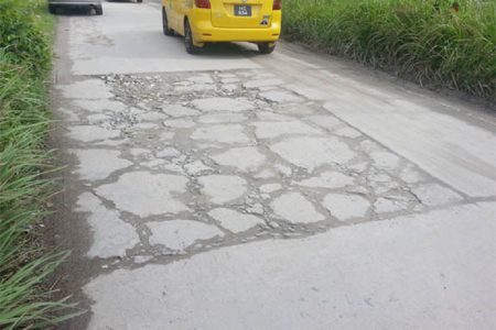 A roughly patched portion of the road.
