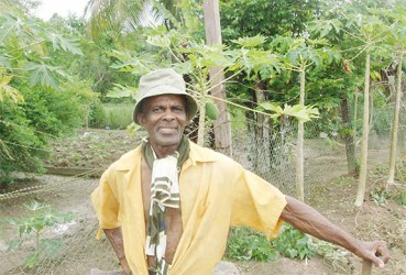 Burnell Hubbard standing in his farm 