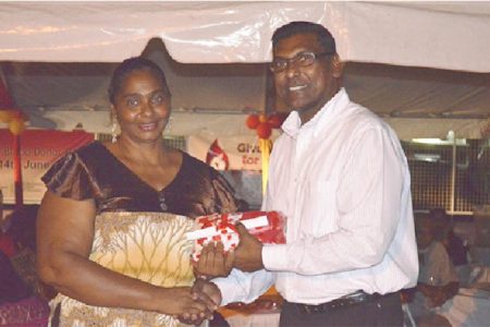 Chief Medical Officer, Dr. Shamdeo Persaud (right) handing over a token to a blood donor. (GINA photo)