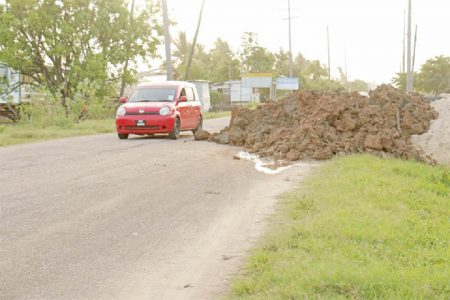 Dangerous: A pile of mud dumped on the Railway Embankment in Buxton, East Coast Demerara has taken over half of the road, turning it into a one-way at the point. There are no street lights in that area. (Photo by Arian Browne)