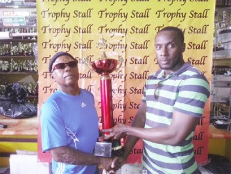 Employee of the Trophy Stall, Ryan Sealey, handing over the best lifter trophy to GAPF’s Erwyn Smith. 