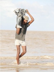 Playing it safe: This fisherman fetches his outboard  engine which he has removed from his boat for  safety’s sake. (Photo by Arian Browne)