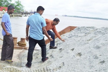 Minister of Natural Resources and the Environ-ment Robert Persaud examines the stone whilst Vishnu Ramdial of Durban Quarries looks on.  (GINA photo)